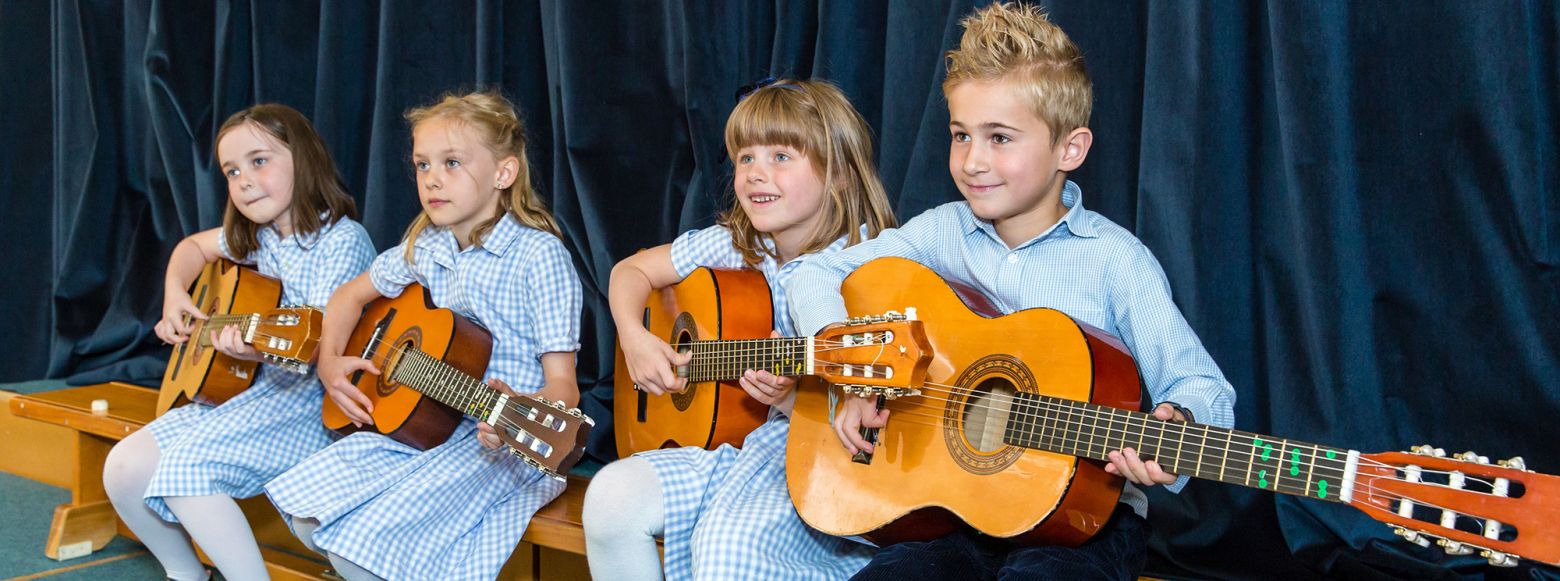 children from a London prep school playing the guitar