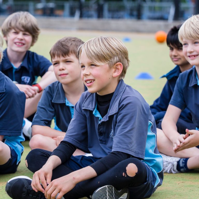 children from a London prep school sitting down and smiling