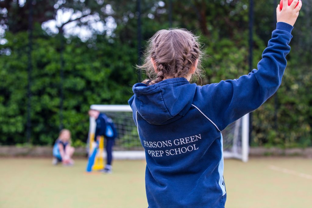 A girl from Parsons Green Prep School throwing a ball