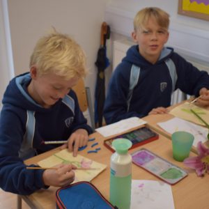 two boys painting flowers