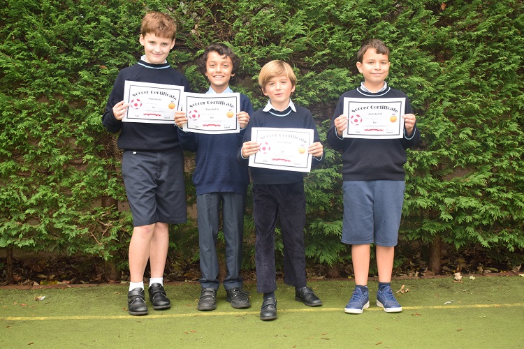 Students at a Prep School in West London holding their soccer certificates