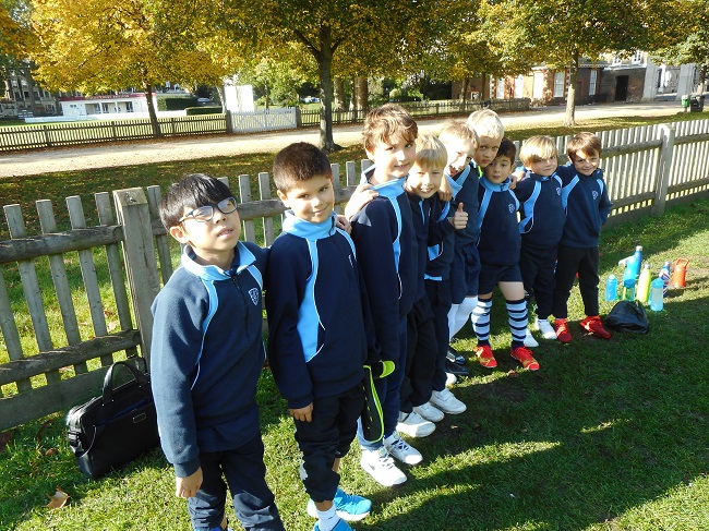 A boys football team at a London prep school huddling together