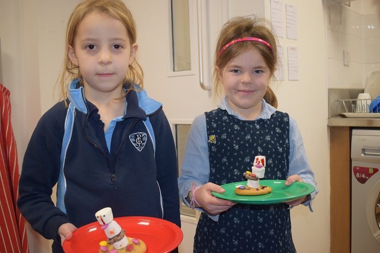Two girls with cookies that they have baked at prep school