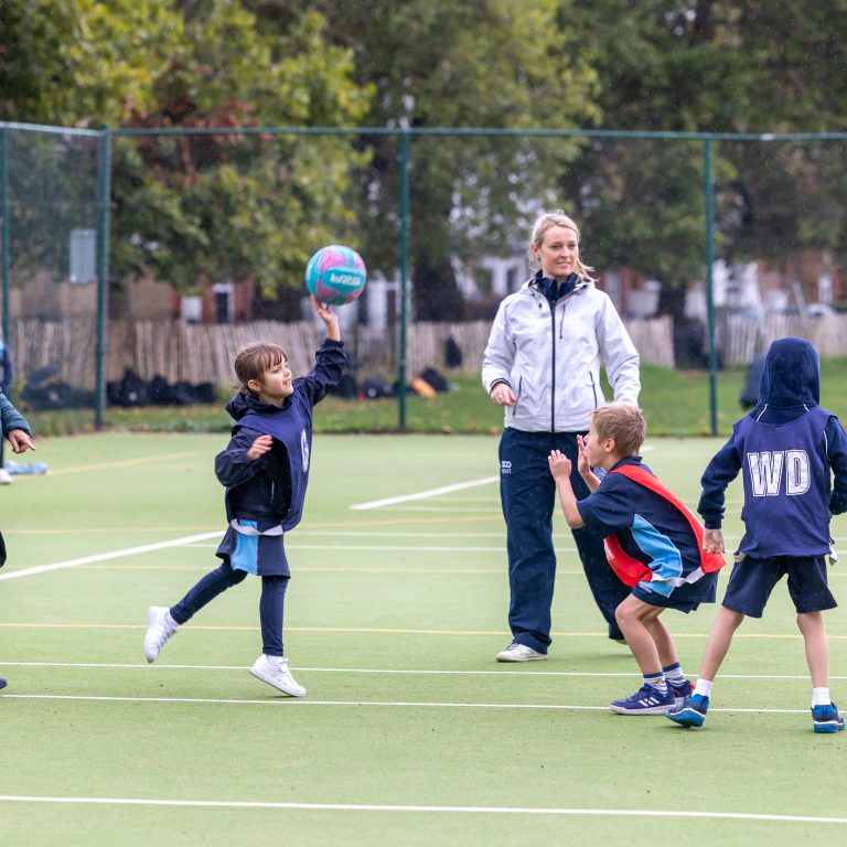 girl throwing ball to child