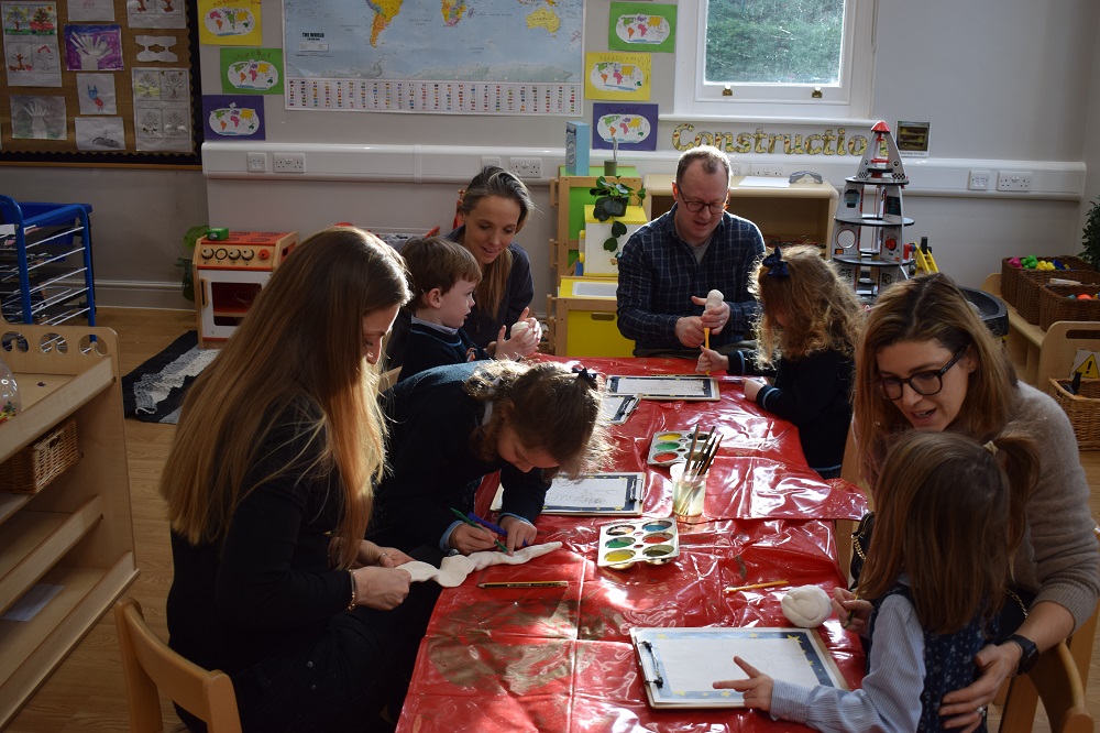 students and teachers working together on a small art project