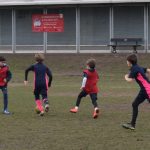 4 students running across the football pitch