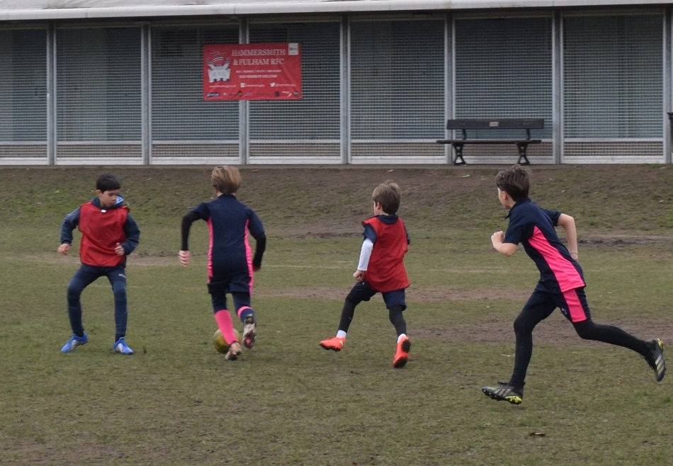 4 students running across the football pitch
