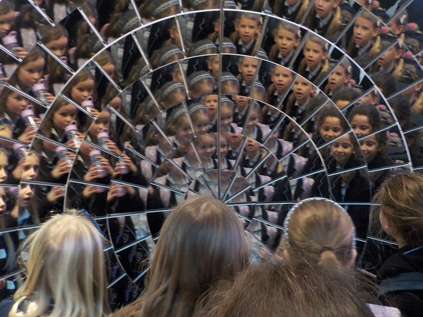 children looking into a huge wall of mirrors