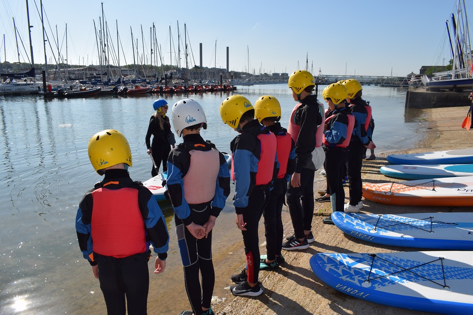 students getting ready for a paddleboarding sessions