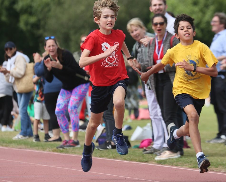 2 boys running on the athletics track