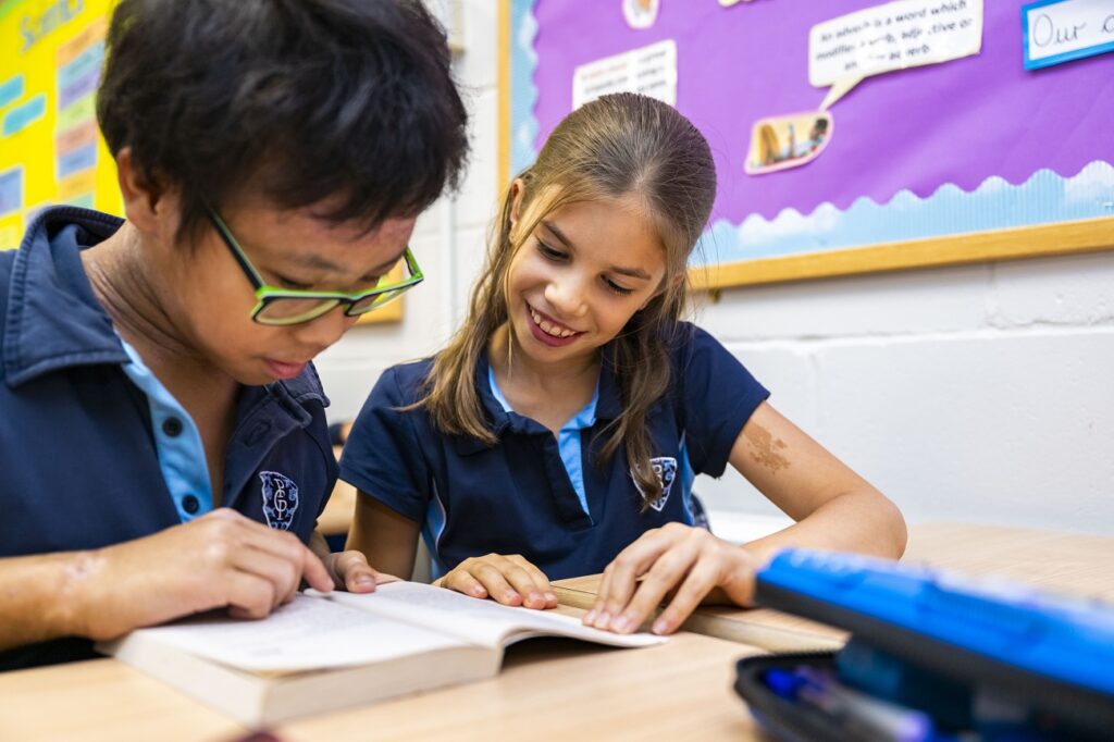 2 students looking at a book