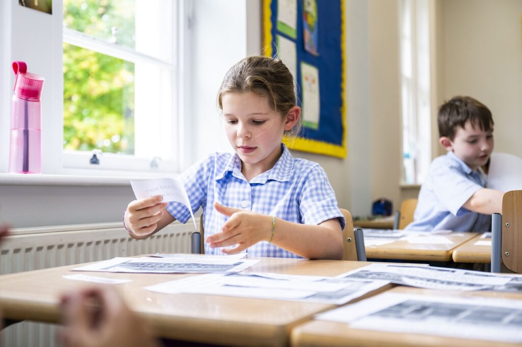 girl cutting up pieces of paper