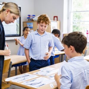 teacher looking over students' work